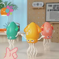 Three dancing squid toys in green, yellow, and pink with glowing lights and music notes – dancing squid toy for toddlers